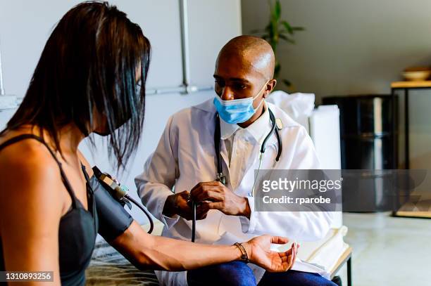 A black doctor doing the examination with a stethoscope on a transgenero woman