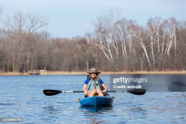 fille dans le kayak sur le lac au début du printemps - girl rowing boat photos et images de collection