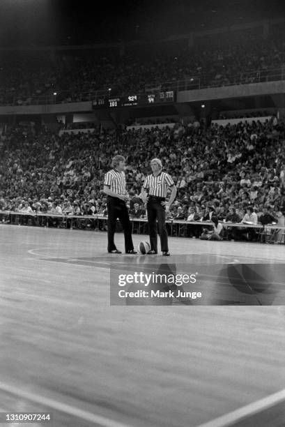 American Basketball Association referees stand at the top of the key during an ABA basketball game between the New York Nets and the Denver Nuggets...