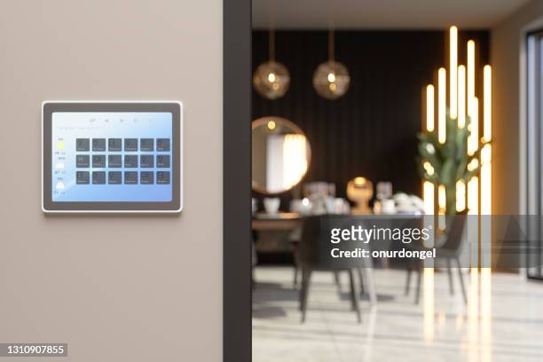 sistema de control de inicio inteligente con iconos de aplicación en una pantalla digital en comedor con fondo borroso - connected home fotografías e imágenes de stock