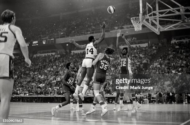 Denver Nuggets guard Ralph Simpson drives into Kim Hughes and Julius Erving for a layup during an ABA basketball game against the New York Nets at...