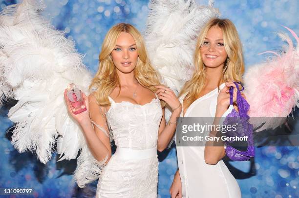 Victoria's Secret supermodels Candice Swanepoel and Erin Heatherton pose for pictures at the Victoria's Secret launch of the Angel fragrance and the...