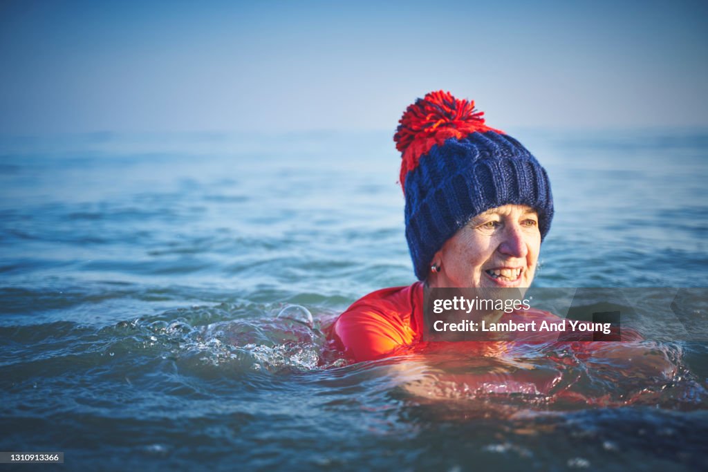 Active senior going for a winter swim wearing a thick wooly hat