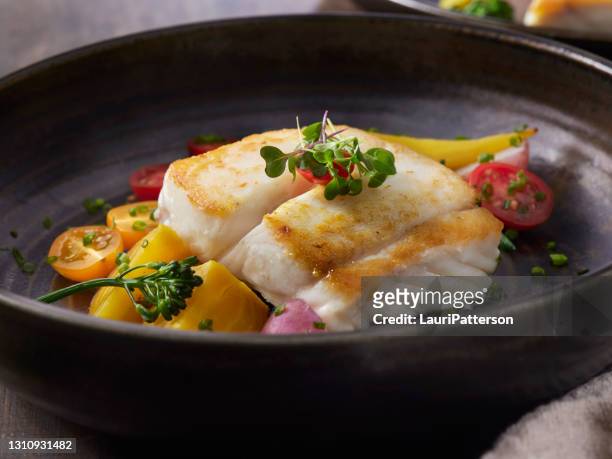 pan seared halibut with pumpkin seed gremolata with a coconut curry sauce - cod dinner stock pictures, royalty-free photos & images