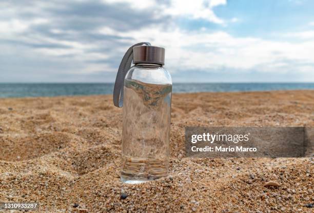 water bottle on the beach - reusable water bottle beach stock pictures, royalty-free photos & images