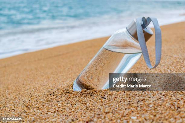 water bottle on the beach - reusable water bottle beach stock pictures, royalty-free photos & images