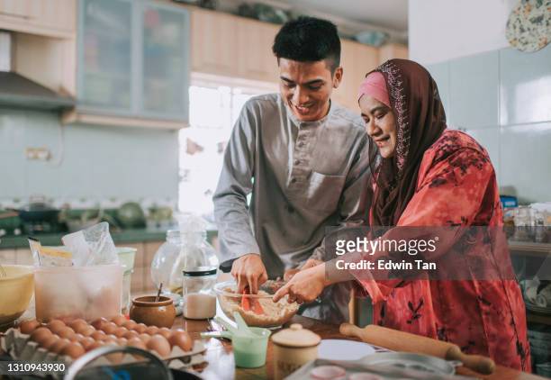 top angle malaysian malay adult offspring helping mother baking in kitchen preparing family at home celebrating hari raya - ramadan celebration stock pictures, royalty-free photos & images