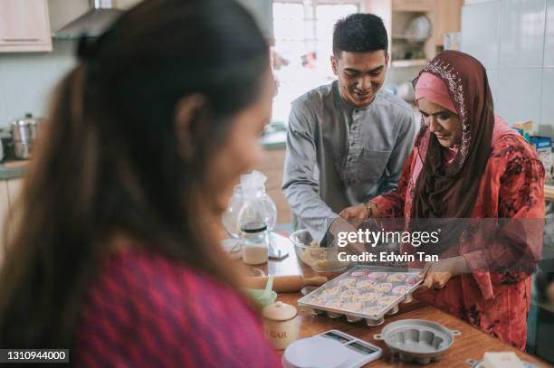 ramadan malaysische nmalay geschwister erwachsenen nachkommen hilft mutter backen in der küche vorbereitung familie zu hause feiern hari raya - hari raya celebration stock-fotos und bilder