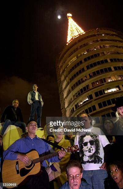 Fans sing John Lennon songs near the Capital Records Tower building December 8, 2000 in Hollywood, CA, as they remember the former Beatle guitarist,...
