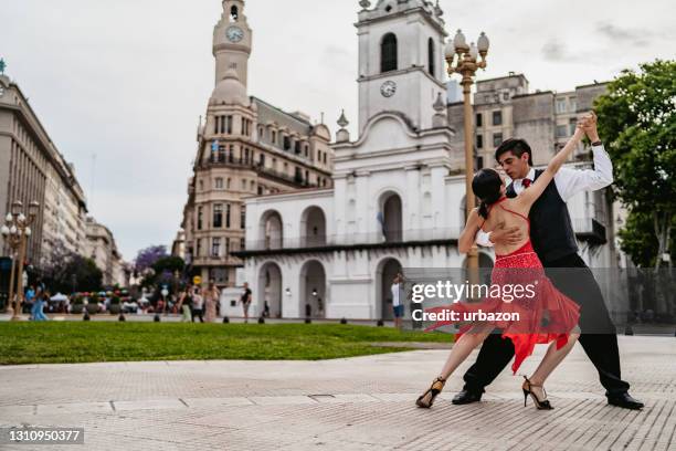 lateinisches paar tanzt tango auf dem stadtplatz - tango tanz stock-fotos und bilder