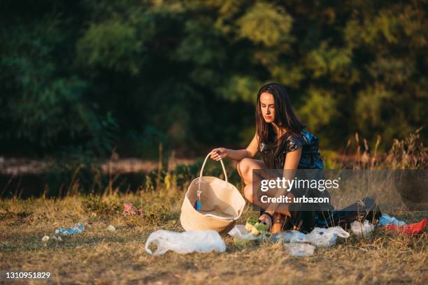 woman picking garbage in nature - trash bag dress stock pictures, royalty-free photos & images