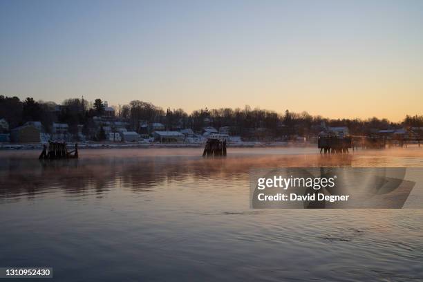Fog rises in front of Bucksport on February 10, 2021 in Bucksport, Maine United States. The USCG 65' small harbor tugs Tackle and Bridle work on an...