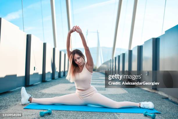 athletische weibliche durchführung full split übung während bridge training - spagat frau stock-fotos und bilder