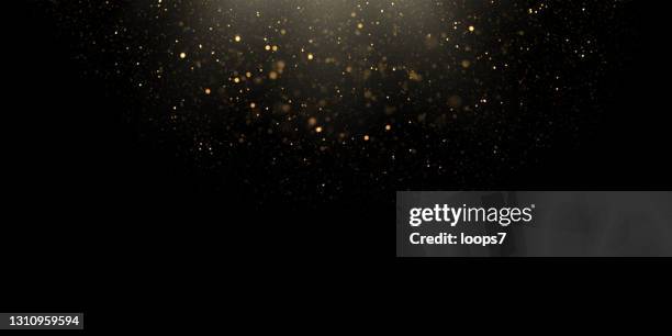 ilustrações de stock, clip art, desenhos animados e ícones de blurred particles and golden defocused lights over black background - black color