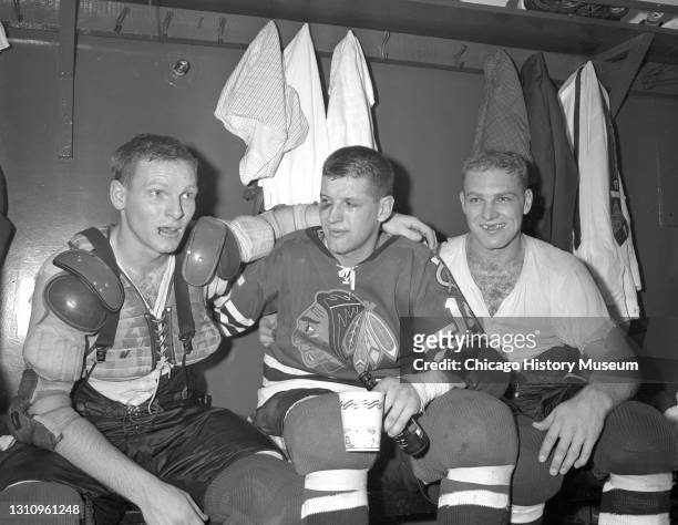 Chicago Blackhawks hockey players Bill Hay , Eric Nesterenko, and Bobby Hull sit in the locker room after defeating the Detroit Red Wings during the...