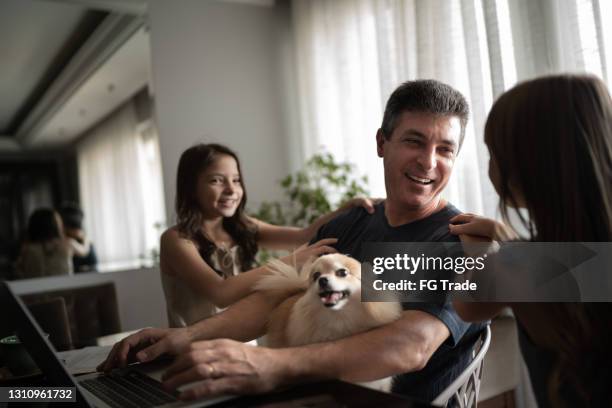 在家工作的父親抱著狗和女兒擁抱他 - animal related occupation 個照片及圖片檔