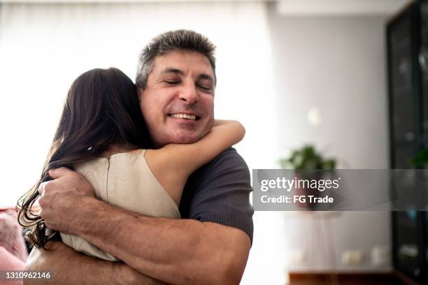 hija abrazando a padre en casa - fathers day fotografías e imágenes de stock