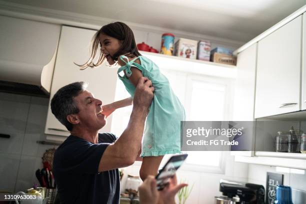 vader lifiting dochter in de lucht thuis - dad throwing kid in air stockfoto's en -beelden