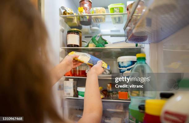 girl taking raw food from refrigerator - bulges stock pictures, royalty-free photos & images