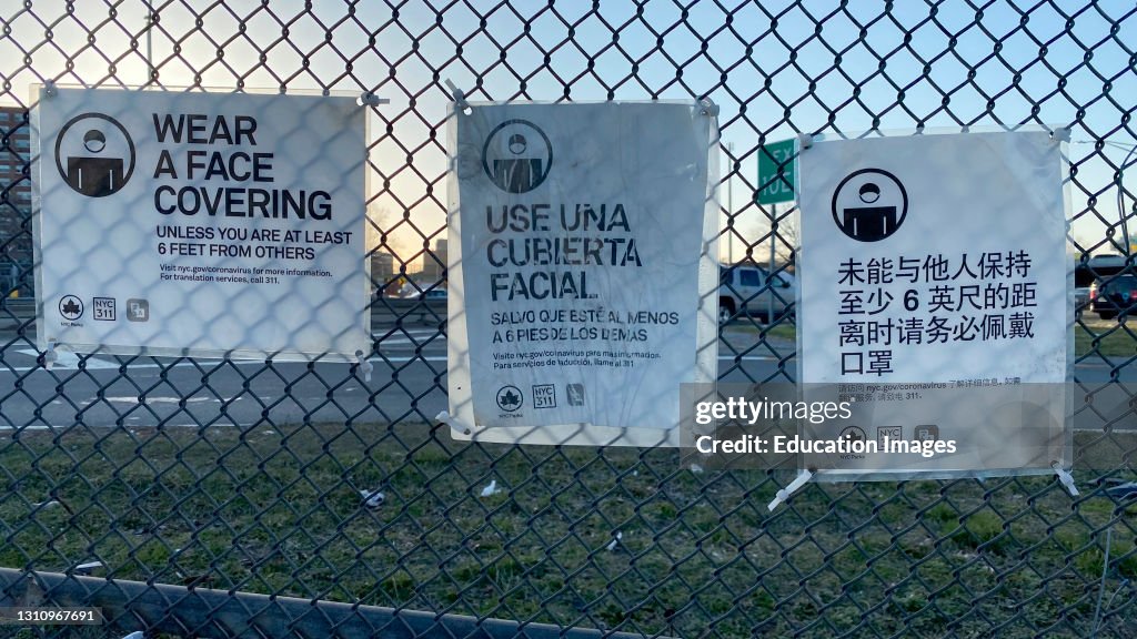 Wear a Face Covering sign in three languages, Flushing Meadows Corona Park, Queens, New York