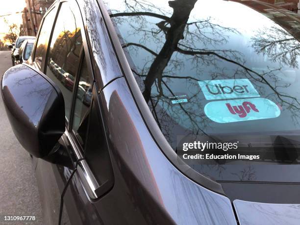 Uber and Lyft sign in windshield of car, Queens, New York.