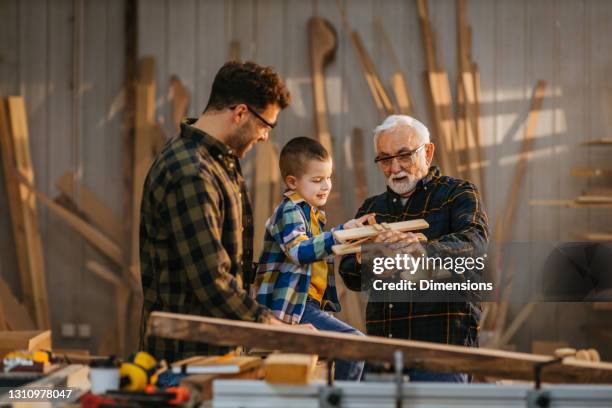 liten pojke leker med far och farfar i deras verkstad - father son business bildbanksfoton och bilder