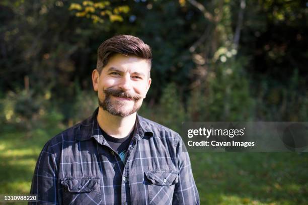 outdoor portrait of a forty year old man with facial hair. - plaid shirt stock-fotos und bilder
