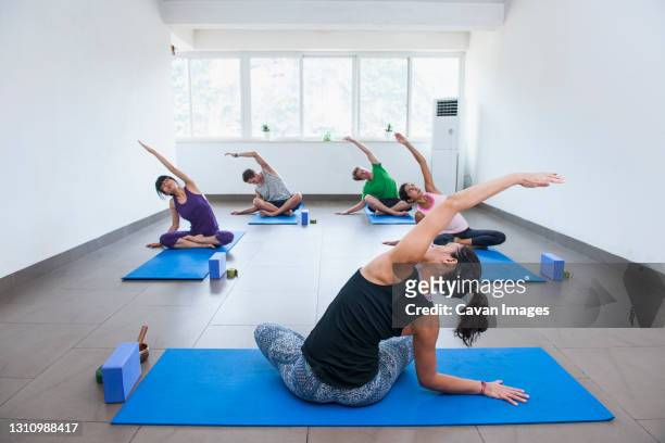 yoga teacher instructing group in yangshuo - yoga studio stock pictures, royalty-free photos & images