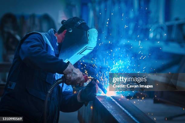 man with protective face and eye shield welding industrial steel beam - 33 arches stock pictures, royalty-free photos & images