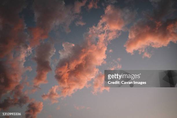 abstract view of clouds turning pink at sunset - goldene stunde stock-fotos und bilder