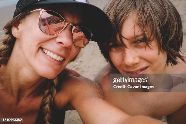 mother and son pose for a selfie on the beach - mature woman and son imagens e fotografias de stock