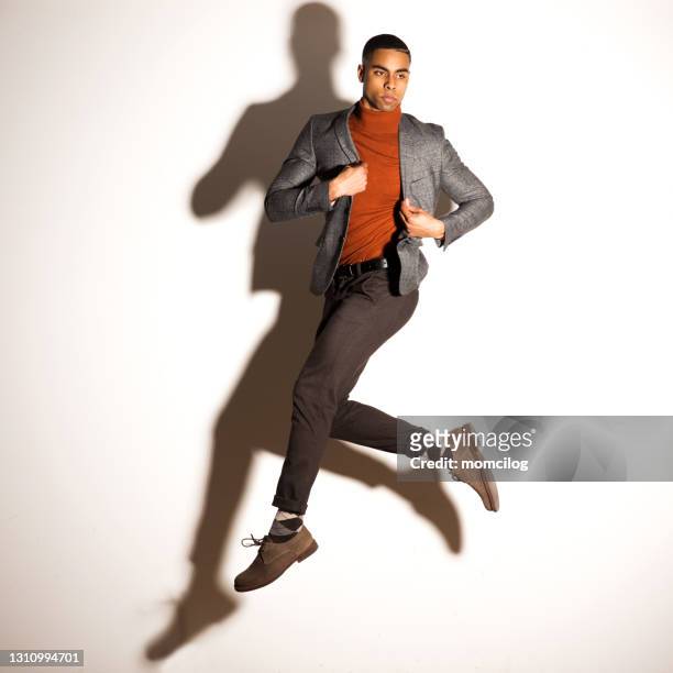 portret van een jong knap mannetje dat in studio springt - male model casual stockfoto's en -beelden