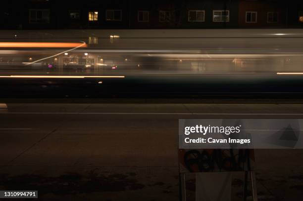 fast passenger train moves through a street at night (motion blur) b - fast motion stock pictures, royalty-free photos & images