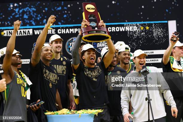 MaCio Teague of the Baylor Bears raises the trophy after defeating the Gonzaga Bulldogs in the National Championship game of the 2021 NCAA Men's...