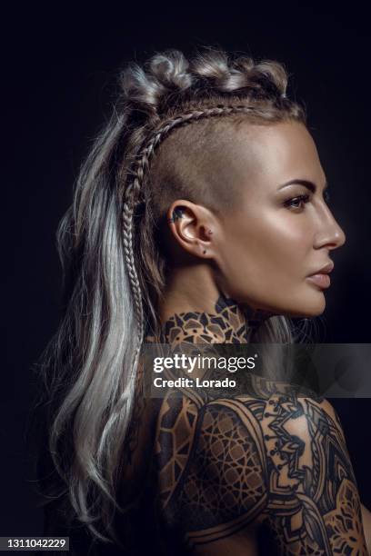 retrato lateral de una mujer rubia vikinga tatuada y su peinado único - corte de pelo con media cabeza rapada fotografías e imágenes de stock