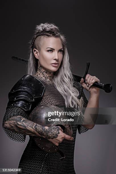 スタジオショットでバイキング戦士ブロンド女性を振り回す剣 - viking ストックフォトと画像