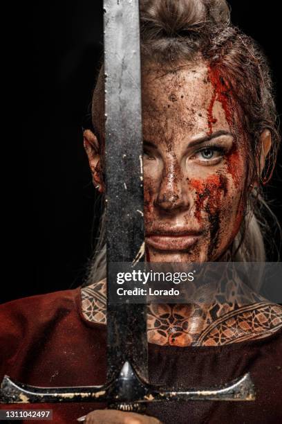 portrait of a blood and mud covered viking warrior queen in studio shot - blood covered stock pictures, royalty-free photos & images