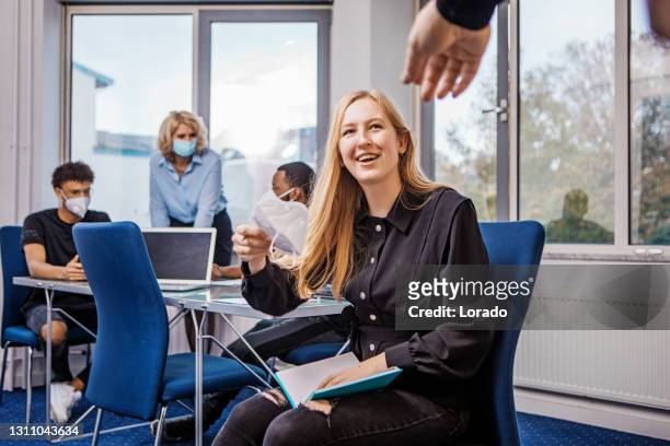 ambiente scolastico in classe con per una bellissima insegnante bionda durante la pandemia di covid-19 - politica e governo foto e immagini stock