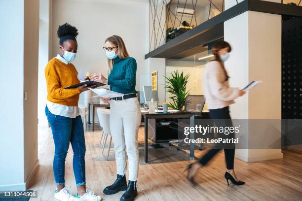 woman at work in the office wearing protective face covering mask - businesswoman mask stock pictures, royalty-free photos & images