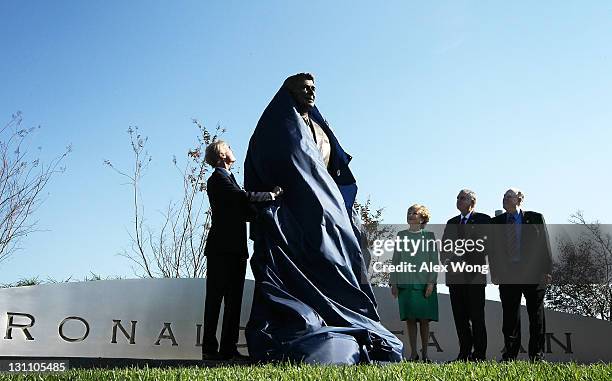 Chairman of Board of Ronald Reagan President Foundation Frederick Ryan unveils a statue of former President Ronald Reagan with former Secretary of...