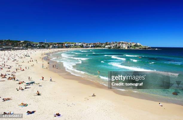 mensen die op het strand bondi in sydney, australië ontspannen - bondi beach stockfoto's en -beelden