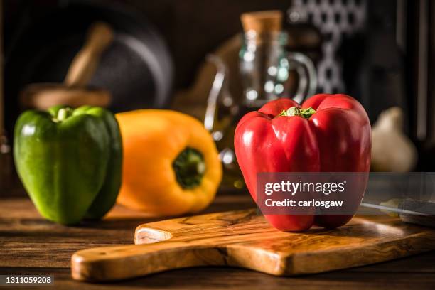 pimientos en una cocina rústica - pimiento dulce fotografías e imágenes de stock