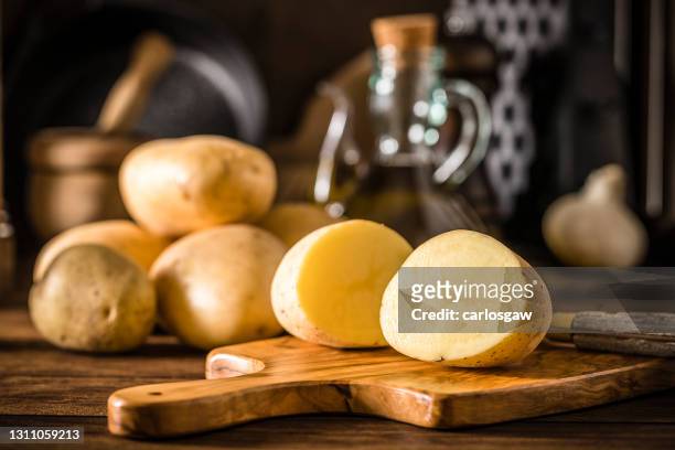 sliced raw potato on a rustic kitchen - potatoes stock pictures, royalty-free photos & images