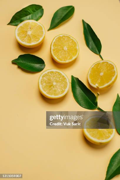 slices of lamon on yellow background - juicy stock pictures, royalty-free photos & images