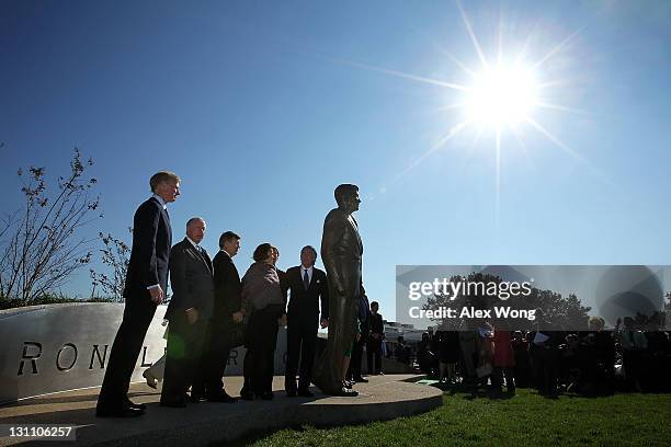 Guests pose for photos with a statue of former President Ronald Reagan during its unveiling ceremony at Ronald Reagan Washington National Airport...