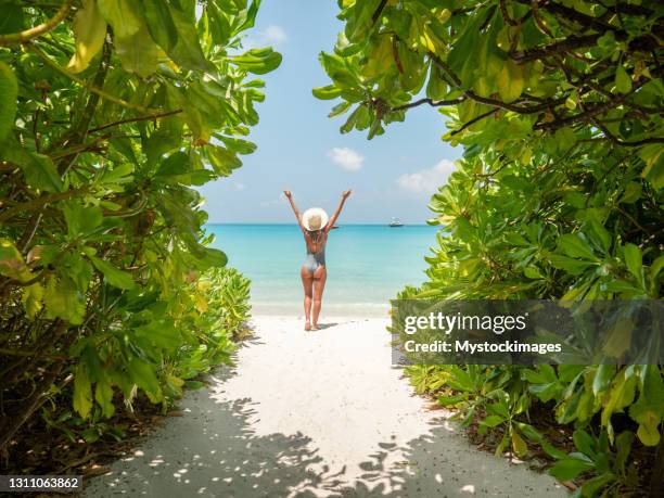 de jonge vrouw loopt naar mooi strand - inviting gesture stockfoto's en -beelden