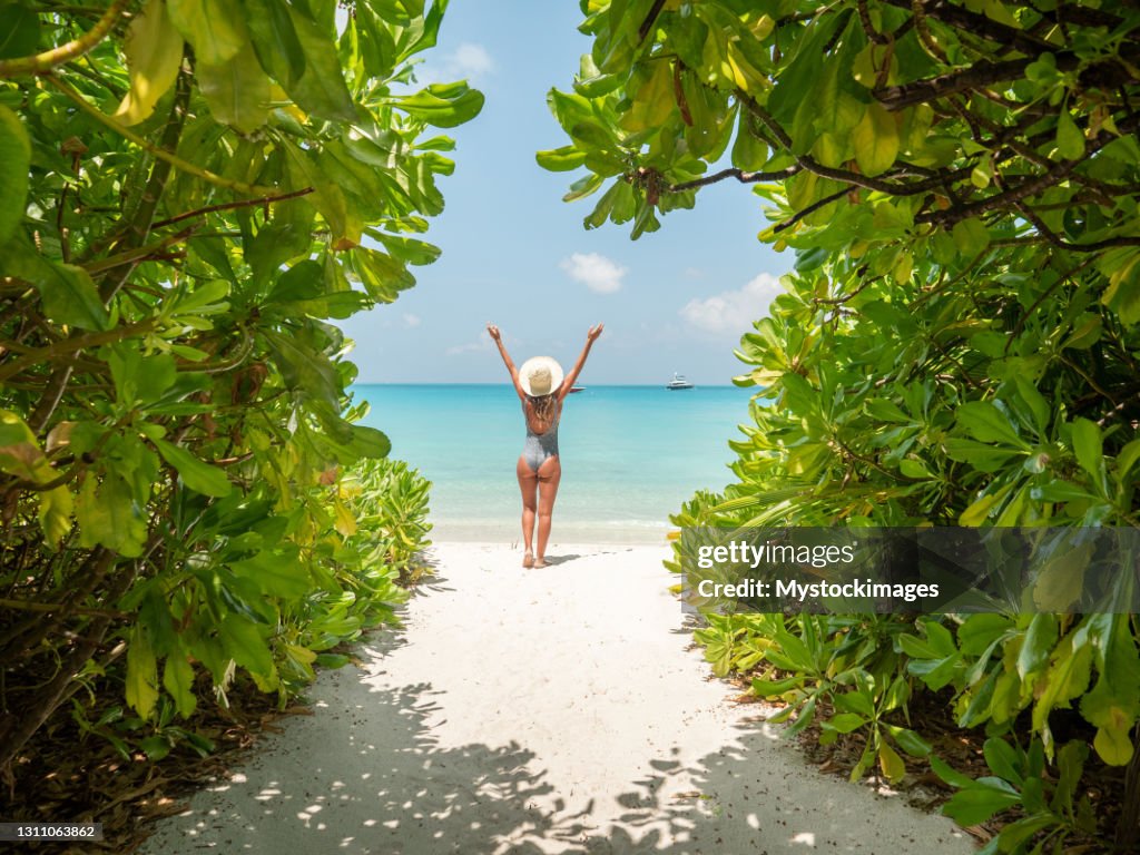 Young woman walks towards beautiful beach