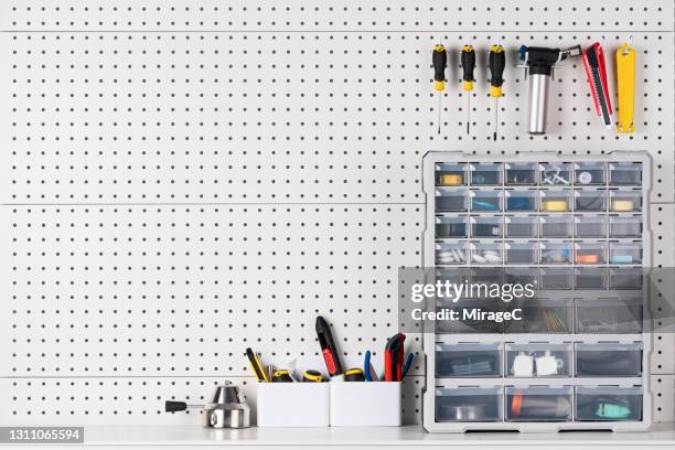 tools hanging on pegboard with toolbox - bancada de carpinteiro imagens e fotografias de stock