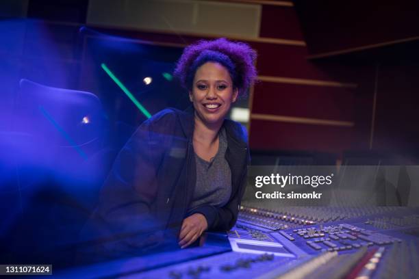 smiling female composer sitting in recording studio - sound engineer stock pictures, royalty-free photos & images