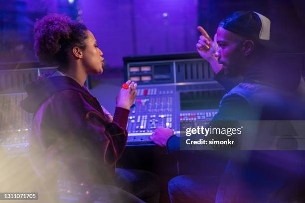 mannelijke componist die met vrouwelijke singer in opnamestudio spreekt - geluidsoverlast stockfoto's en -beelden